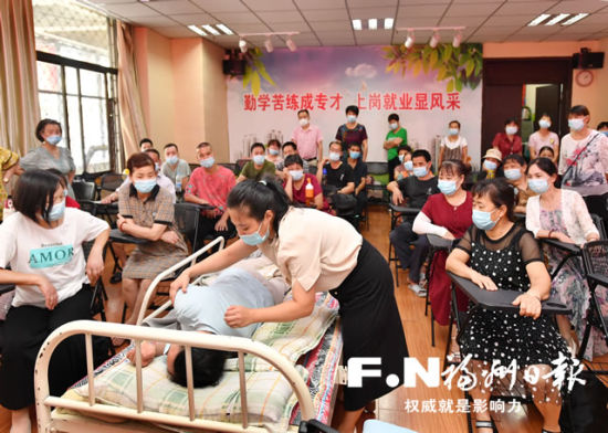 学员们学习如何给病人翻身预防褥疮。记者 叶义斌 摄